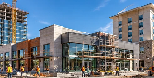 Office, retail, and hospitality buildings at different stages of development line an urban commercial construction area.