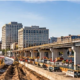 City skyline and bridge work alongside a roadway construction site, showing the range of projects in the construction industry.