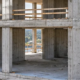 Architect inspects intersecting load-bearing concrete walls in a multistory building, showing the cross-wall structural layout.