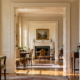 Aligned doorways frame a sequence of sunlit historic rooms, showing the enfilade layout and uninterrupted sightline through a classical home.