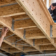Engineer checks timber floor joists and bridging below a residential room to identify ways to reduce floor vibration.
