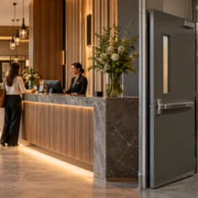 Connected commercial interior showing a welcoming public reception area transitioning to a separate staff service corridor and operations space.