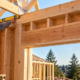 Carpenter checks the top plate at the head of a timber-framed wall above a window opening.