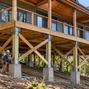 Elevated house on concrete piers with cross-bracing on a hillside, showing its support structure