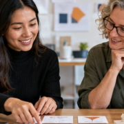 Educator and instructional designer arrange architecture course materials beside a building model and laptop, illustrating learning-content design.