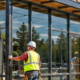 Crew fits storefront glazing on a compact neighborhood retail building, illustrating the smaller scale of light commercial construction.