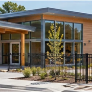 Single-level early learning center with an accessible entrance and fenced play yard, designed for a nursery facility.