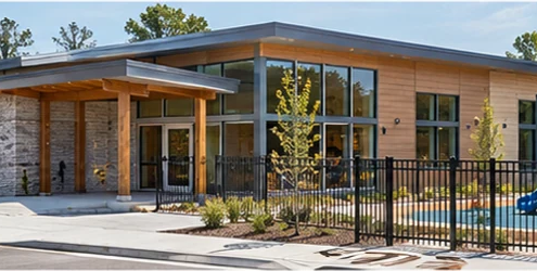 Single-level early learning center with an accessible entrance and fenced play yard, designed for a nursery facility.