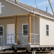 Crew guides a modular chapel into place with a crane on its prepared site, beside an accessible entrance ramp.