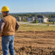 Builder and developer review a surveyed residential lot with plot stakes before new home construction begins.
