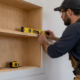 Carpenter aligns a built-in wall niche at the framing stage, showing how recessed shelving sits within the wall plane.