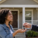 Tenant receives the keys to a detached single-family home, illustrating the rental market for stand-alone houses.