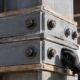 Engineer inspects a bolted steel column splice where stacked vertical structural members align across building levels.