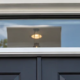 A horizontal glazed transom window sits above a door, separated from the opening by a distinct frame and crossbar.