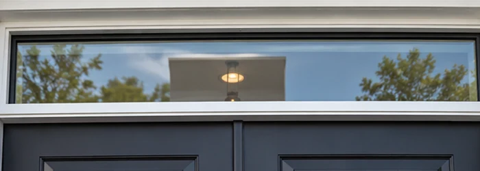 A horizontal glazed transom window sits above a door, separated from the opening by a distinct frame and crossbar.