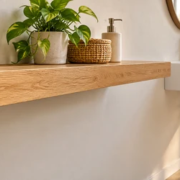 Floating shelf mounted to a wall stud with a concealed metal bracket, beside a wall-mounted basin in a modern room.