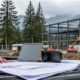 Contractor prepares a commercial project bid with drawings and a laptop at a Pacific Northwest construction site.